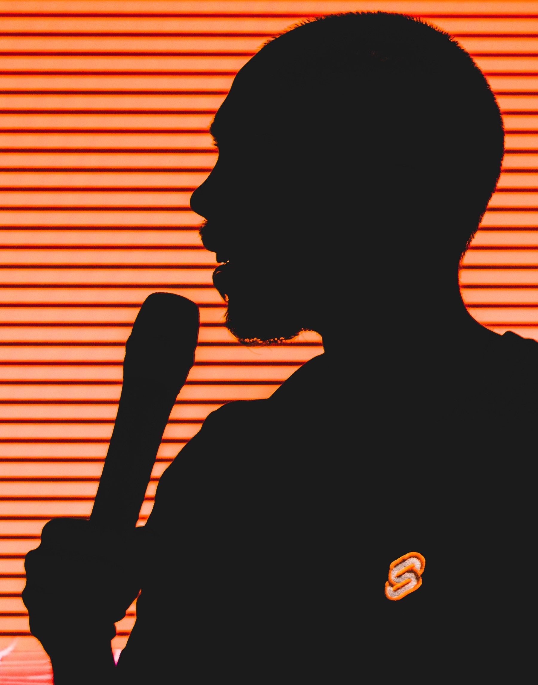 Silhouetted speaker against an orange stage screen at Svelte Summit Fall 2022.